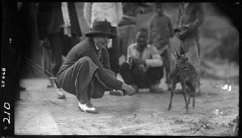 People gather around small animal