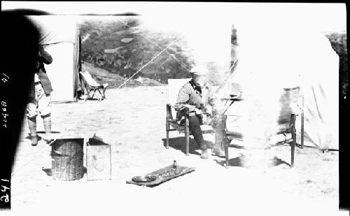 Man sits in chair outside tent