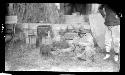 Man crouches on ground, holding tail of cat