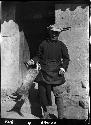 Man stands in doorway holding animal