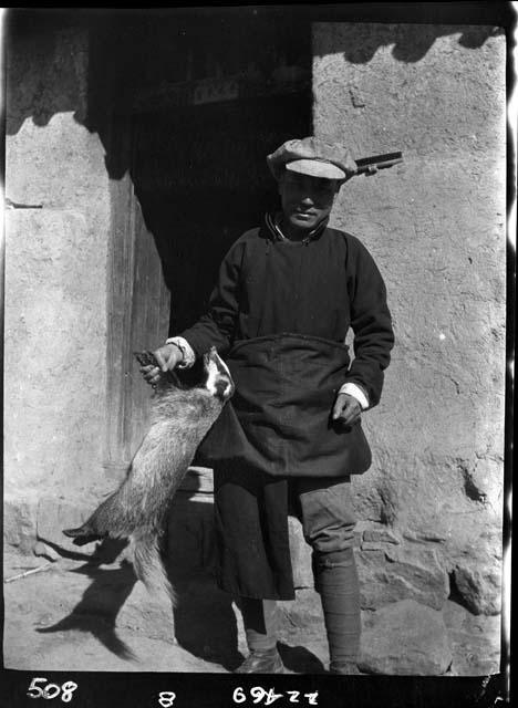 Man stands in doorway holding animal