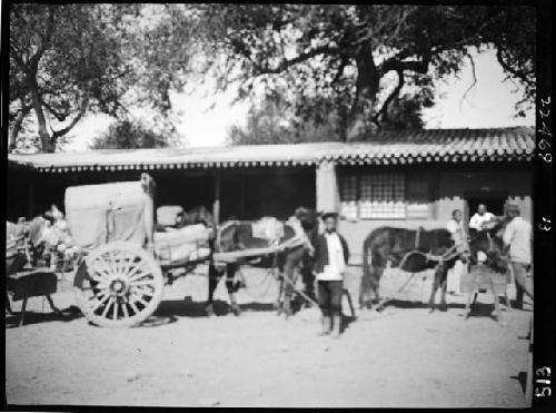 Horses and carts in front of building