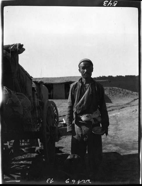 Man stands next to wagon