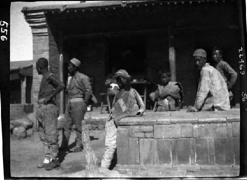 People sitting and standing outside building