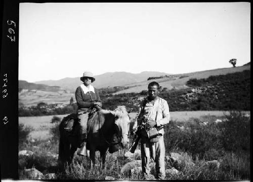 Man walks in front of woman on horse