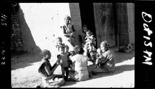 Women and children sitting in sunlight