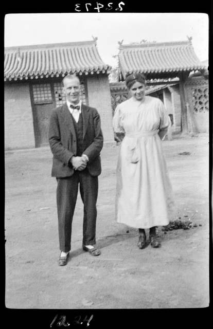 Man and woman stand outside building