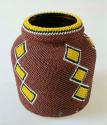 Jar covered with brown beadwork with yellow diamond design