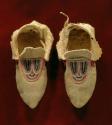 One pair of skin moccasins with bead decoration - pink, purple ribbon also used