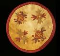 Circular skin mat--bound in red ribbon. floral design embroidery in color