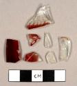 Ruby glass fragments, one fragment melted, possibly from a hurricane lamp