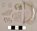 Colorless curved glass fragments, including one partial base and two fragments from a hurricane lamp