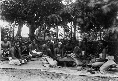 Preparing kawa, Rotuma. Men sitting around three women preparing kawa.