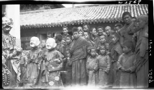 Crowd of people, including children in masks