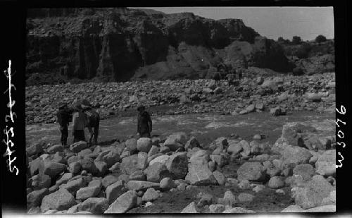 People stand in rocky field