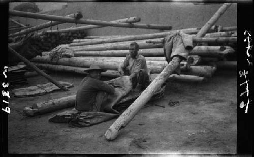 Two men sit at worksite