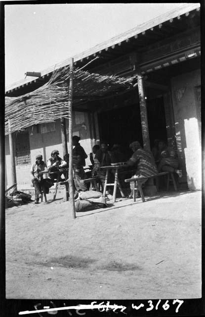 People sit under awning outside