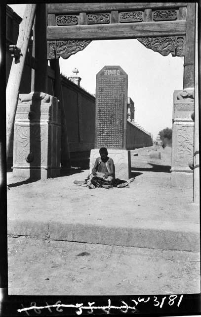 Person sitting outside gate