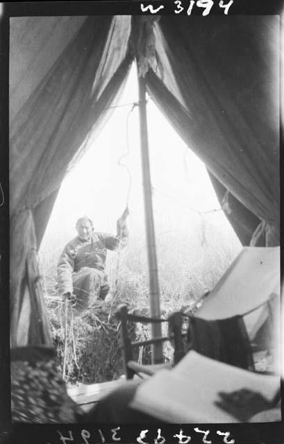 Person sitting outside tent