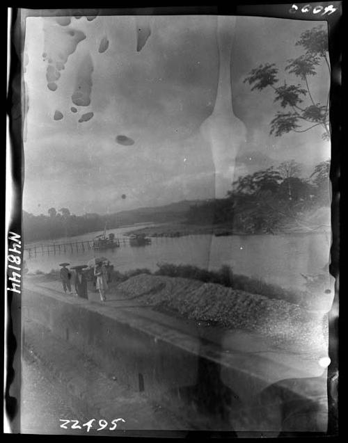 People walk along river