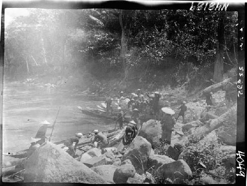 People and boats along riverbank