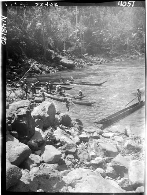 People and boats along riverbank