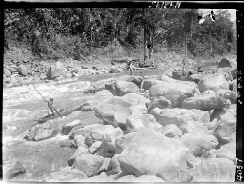 People navigate boats around rocks