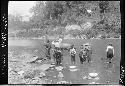 People wade out in river