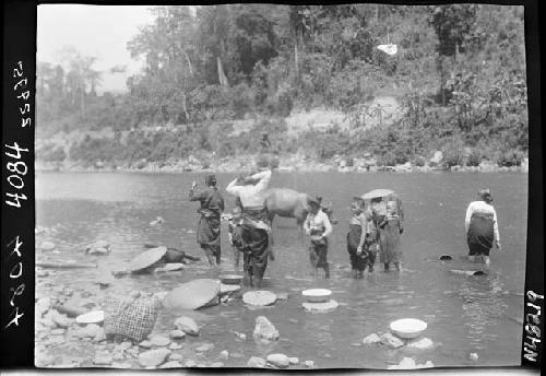 People wade out in river