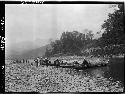 People boarding boats along riverbank