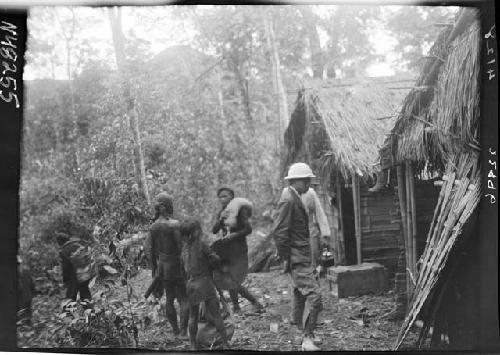 People stand outside huts