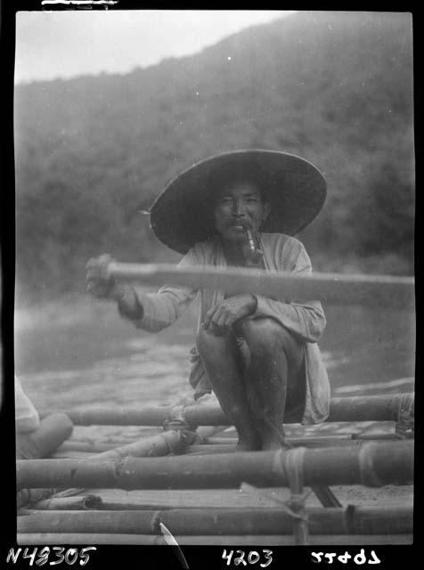 Man crouches on boat