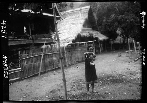 Woman standing outside, resting arm on object