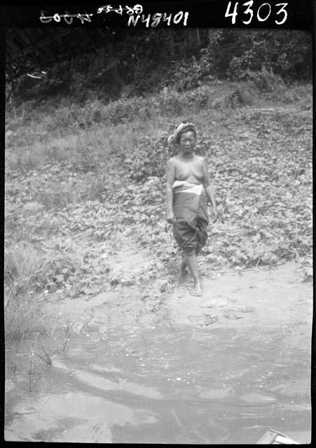 Woman stands on riverbank