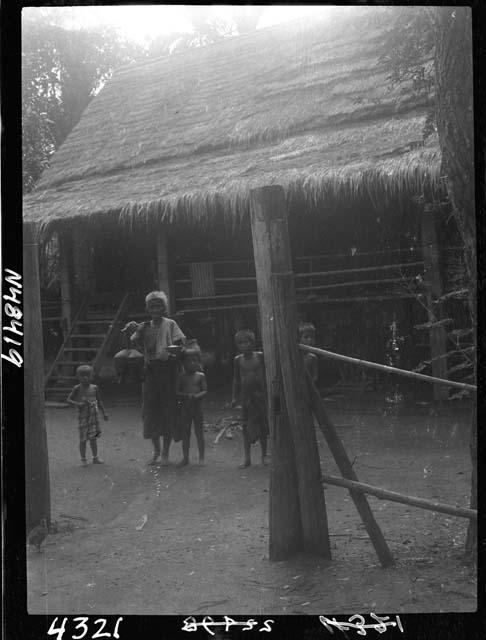 Adult and children stand outside building