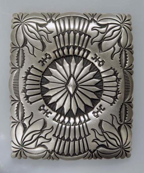 Silver belt buckle, rectangular with overall stamped designs. 7.8 x 6.5 cm.