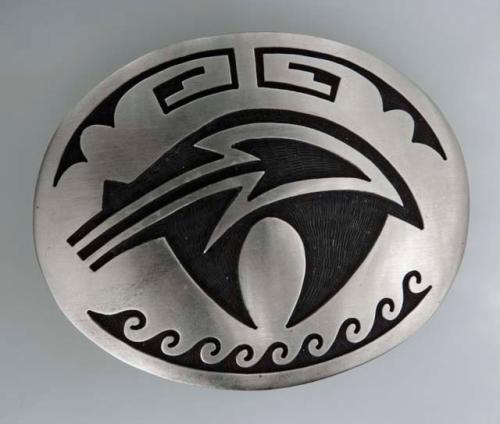 Belt buckle, small oval with an overlaid design of a center curved arrow, waves