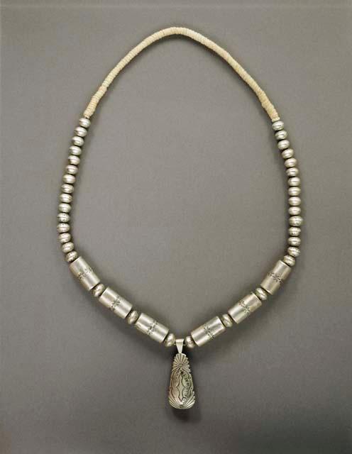 Necklace, a single strand of silver beads, some stamped, with 6 stamped cylinder