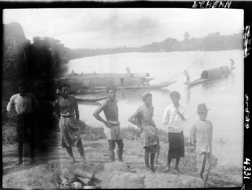 Boys stand along river