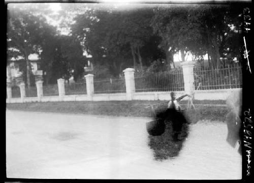 Fence and person carrying baskets