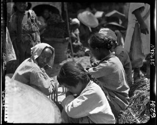 Women and children seated outside