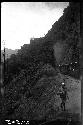 Man walking on road, with train in background