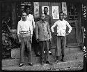 Five men stand on steps outside building