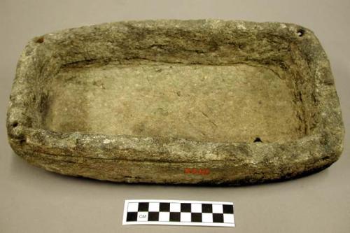 Ground stone, rectangular vessel, two perforations in each corner