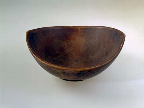 Bowl, carved wood, flared sides, rim peaked at opposite ends, abraded