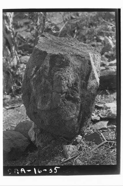 Human face carved in round in same court as carved stone figure