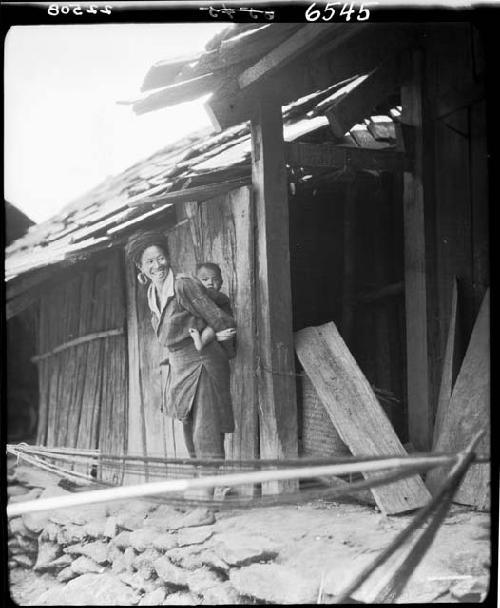 Woman holding child outside building