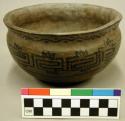Ceramic bowl, flared rim, black on brown exterior.