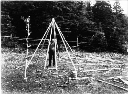 Person standing in wigwam frame