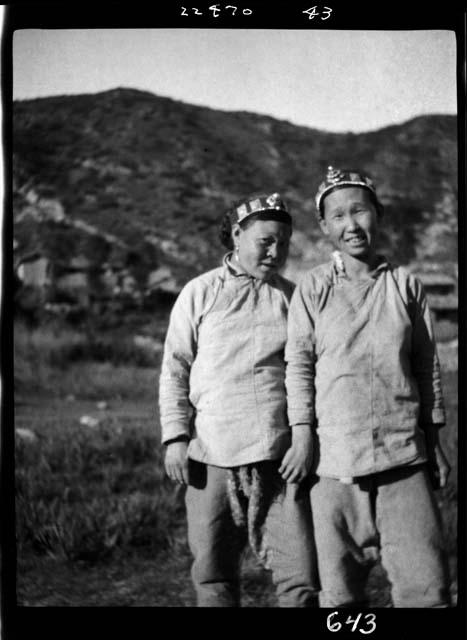 Two women stand outside